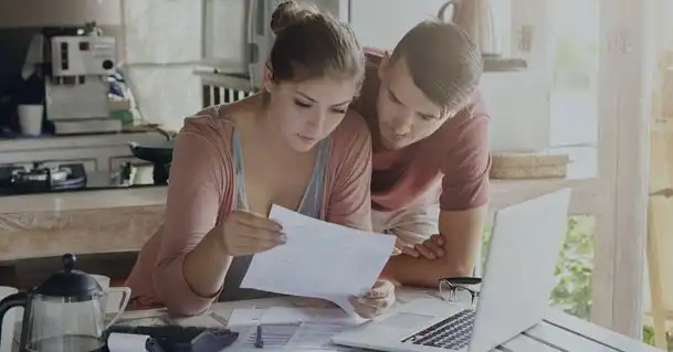 couple qui regarde ses factures avec un ordinateur